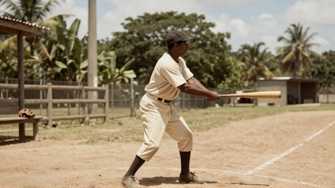 A baseball player in a vintage cream uniform prepares to swing a wooden bat on a rustic dirt field.